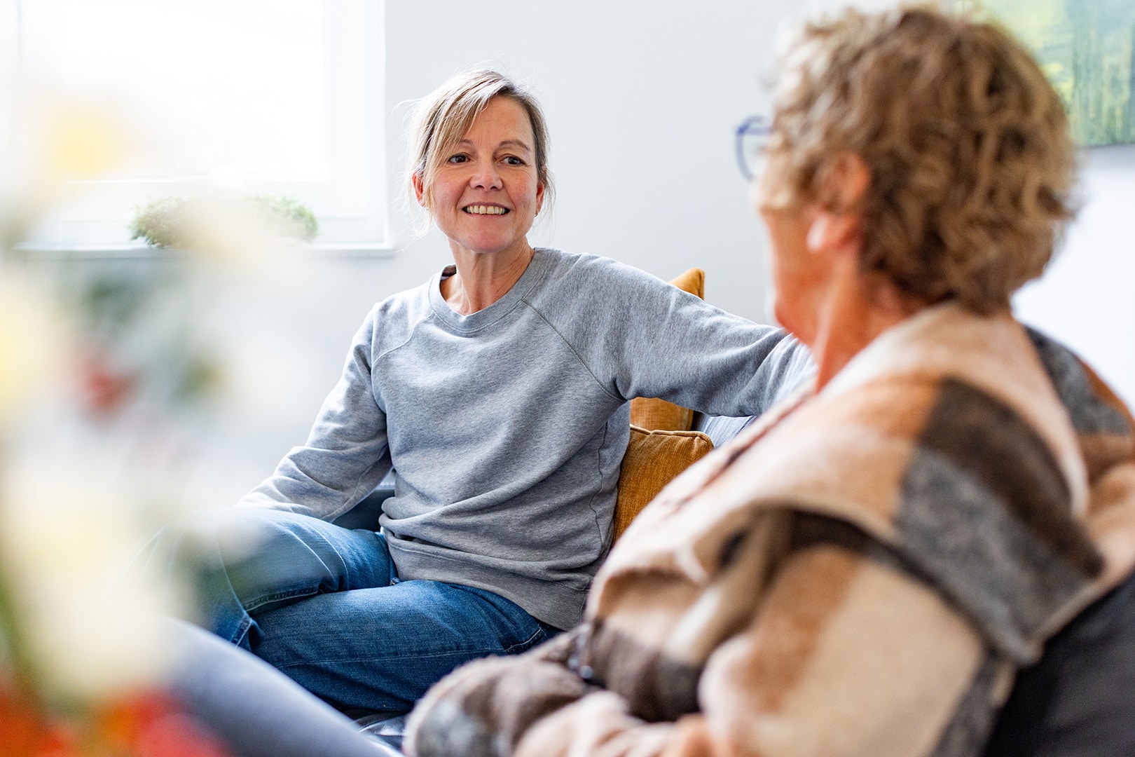 Fachkraft des PKD besucht eine Patientin zu Hause, bietet einfühlsame Unterstützung in vertrauter Umgebung.